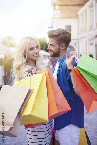 Blonde woman with boyfriends holding shopping bags