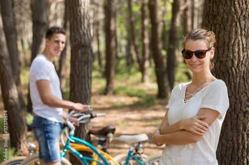 young couple with bicycle in forest