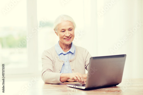 happy senior woman with laptop at home