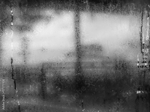 Black and white tone of water drops from home condensation on a window
