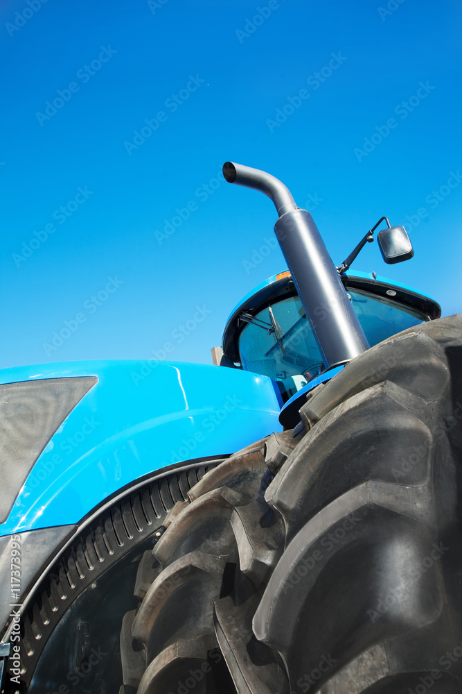 Fototapeta premium Tire on blue tractor close up