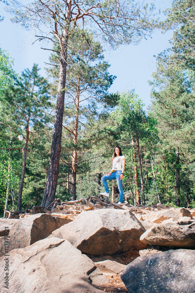 Young girl staying on the mountain rocks; on the top Young girl staying on the mountain rocks; on the top