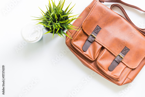Men's fashion leather bag with tree decoration and coffee cup, flat lay, top view background 