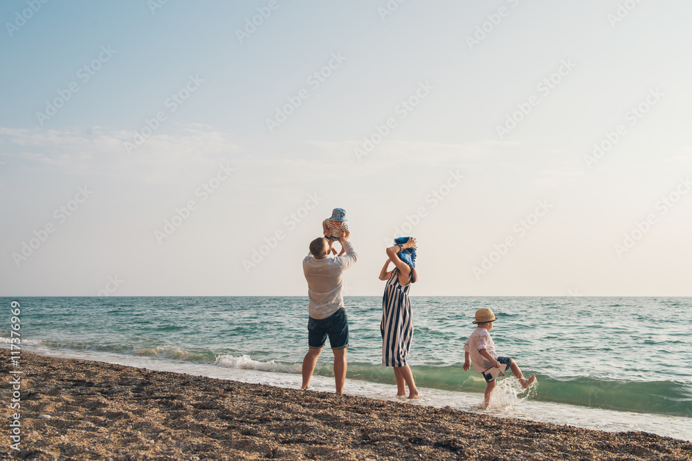 Family with children walking on the sea coast. Family portrait on vacation Family with children walking on the sea coast. Family portrait on vacation