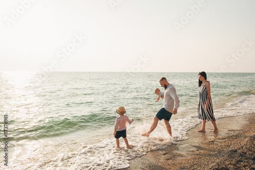 Family with children walking on the sea coast. Family portrait on vacation