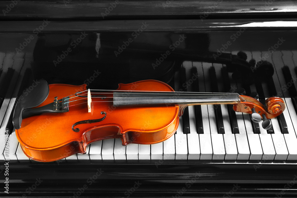 Fototapeta premium Violin on piano keys, closeup