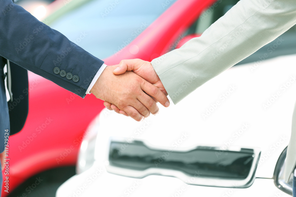 Car sale concept. Customer and salesman shaking hands.