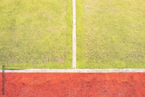 Worn out plastic hairy carpet on outside hanball court. Floor with colorful marking lines. photo