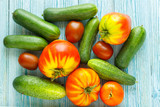 ripe raw tomatoes and cucumbers on wooden background