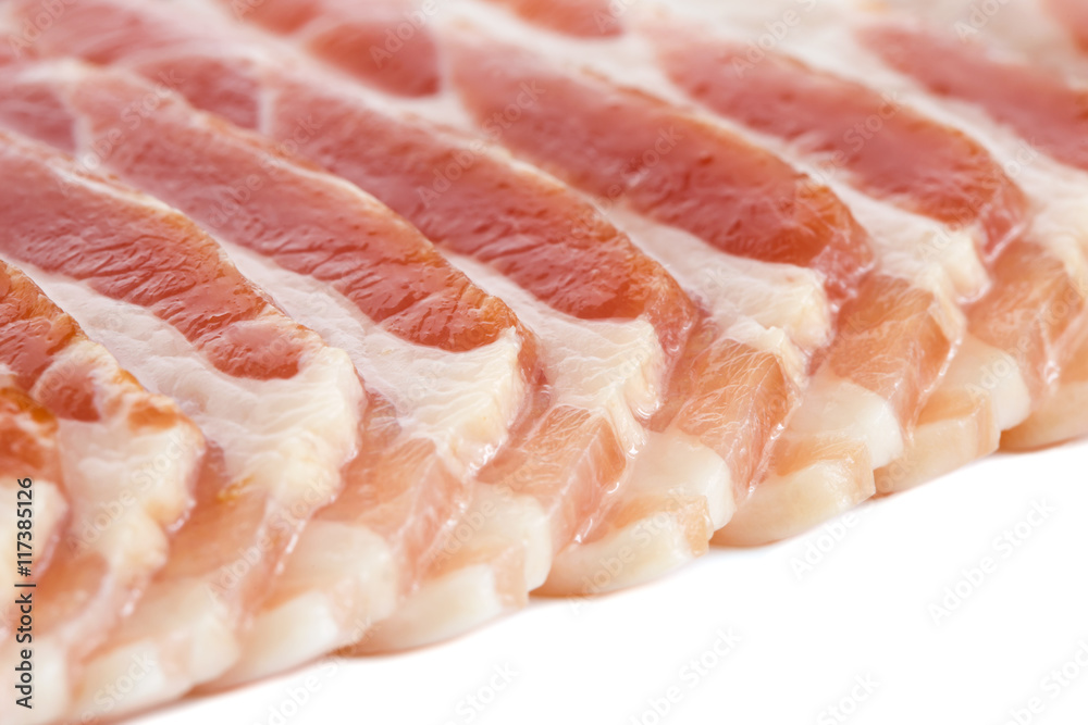 Detail of strips of streaky uncooked bacon isolated on white.