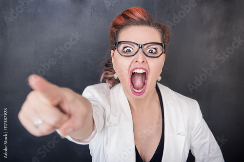 Angry screaming woman pointing out photo