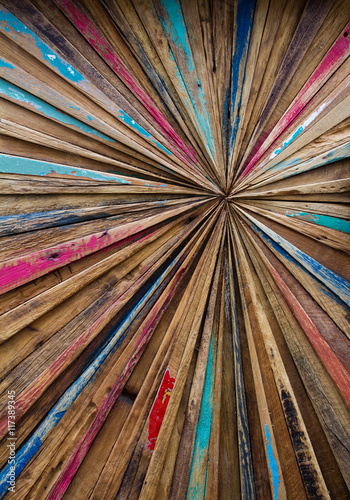 Canvas Print an abstract art image made from distressed, colourful strips of wood that are arranged into a starburst effect with lines converging into a central point