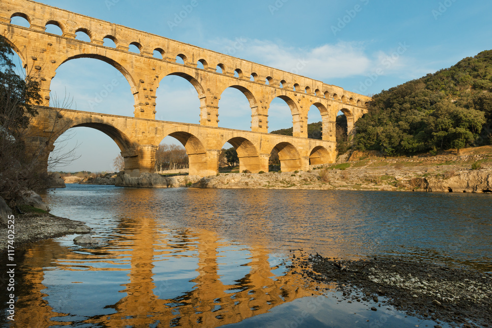 Famous Pont Du Gard reflecting in Gardon river in Southern France