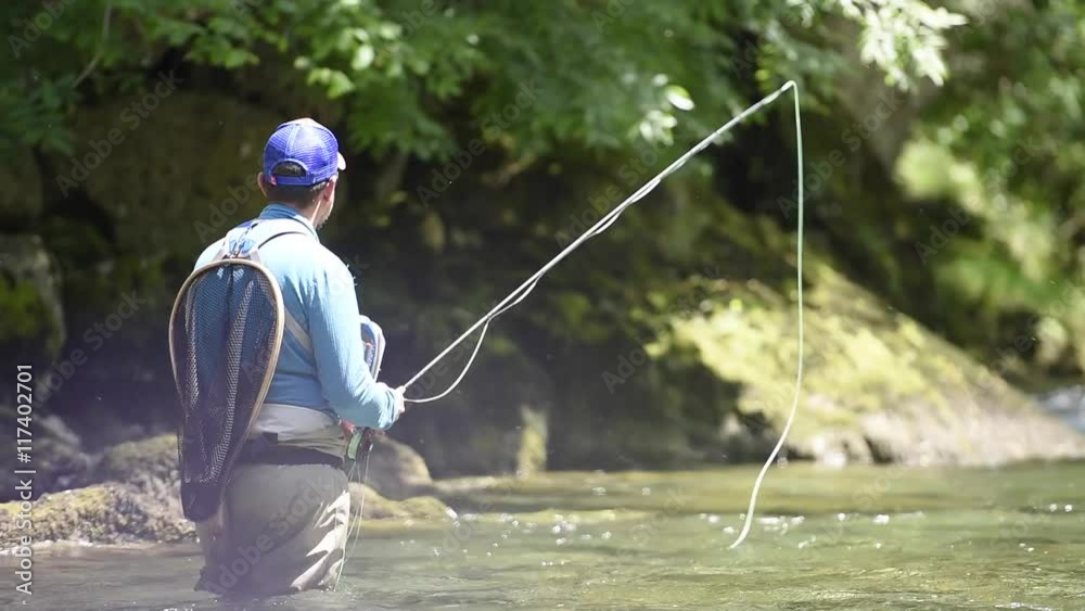 Fisherman fly-fishing in French Pyrenees river Fisherman fly-fishing in French Pyrenees river