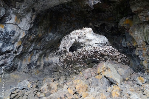 Former lava tube formed by hot, fluid magma. Over time the roof collapsed allowing light into the tunnel and rocks were deposited on the floor. Indian Tunnel, Craters of the Moon National Park.