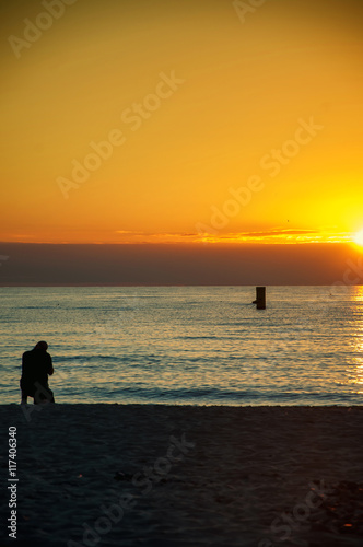 Photographer on the beach at sunset