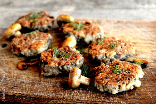 Fried mushroom cutlets decorated with dill on a wooden background. Agaricus recipe. Vegetarian and diet food