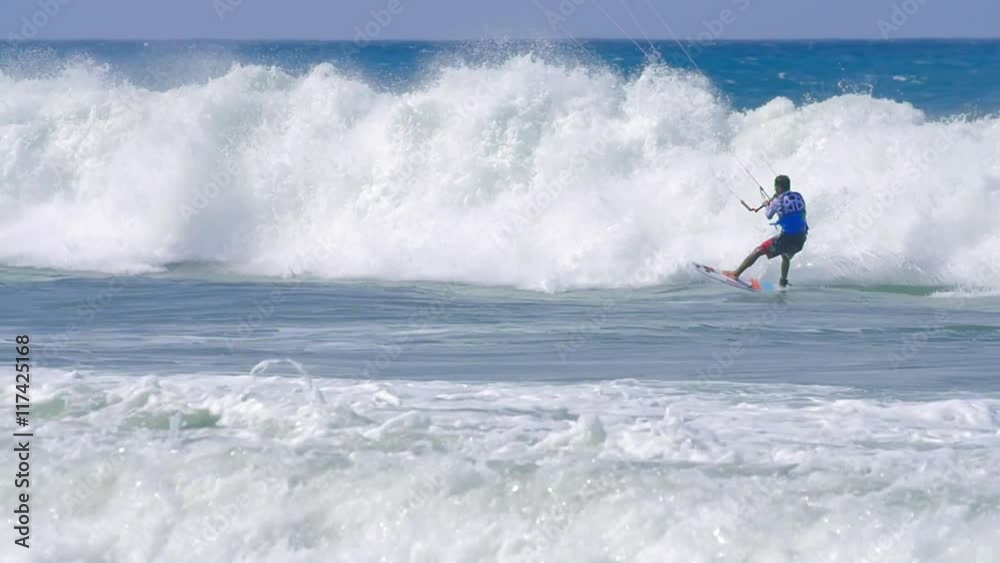 Professional kitesurfer doing tricks on high waves in ocean. Sport background Professional kitesurfer doing tricks on high waves in ocean. Sport background