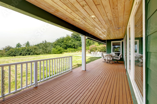 Fényképezés Spacious wooden deck with patio table set. Backyard view