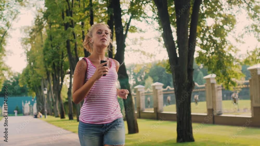 Young beautiful woman running in the park, the sun shines beautifully in the picture Young beautiful woman running in the park, the sun shines beautifully in the picture
