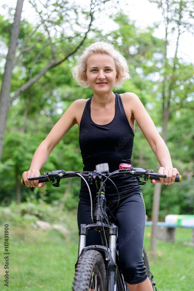 Naklejka premium Fit healthy middle aged woman riding a bike