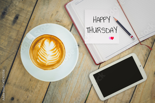 Happy Thursday on paper with coffee cup on wood background