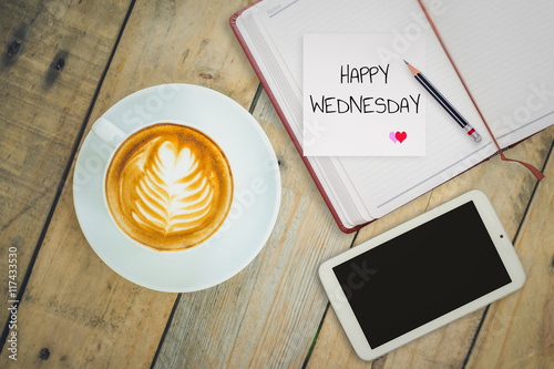 Happy Wednesday on paper with coffee cup on wood background