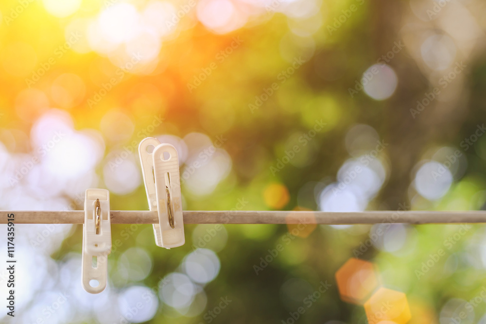 Clothespin hanging on clothesline, nature blur background Clothespin hanging on clothesline, nature blur background
