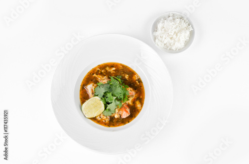 Crab with chili sauce, lime, parsley and rice on a plate on a white background, top view