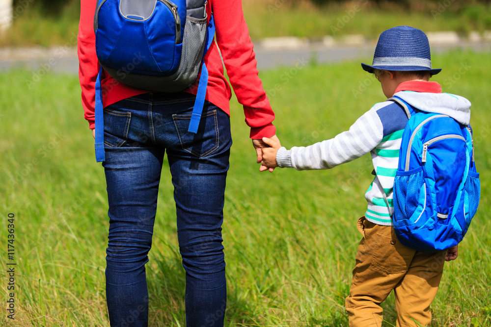 back to school - mother holding hand of little son back to school - mother holding hand of little son