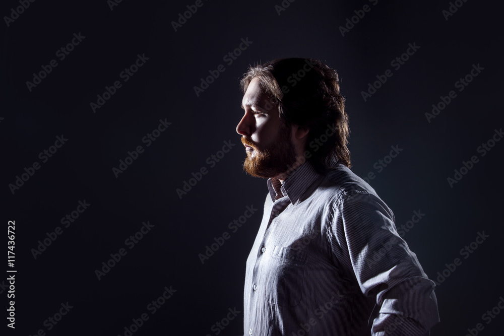 Man with beard, profile on dark background, the silhouette.