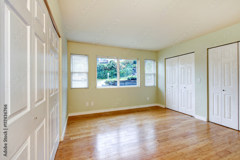 Fototapeta premium Empty room interior with hardwood floor and three closets.