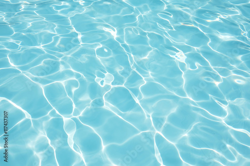 Blue water surface with sun reflection in swimming pool