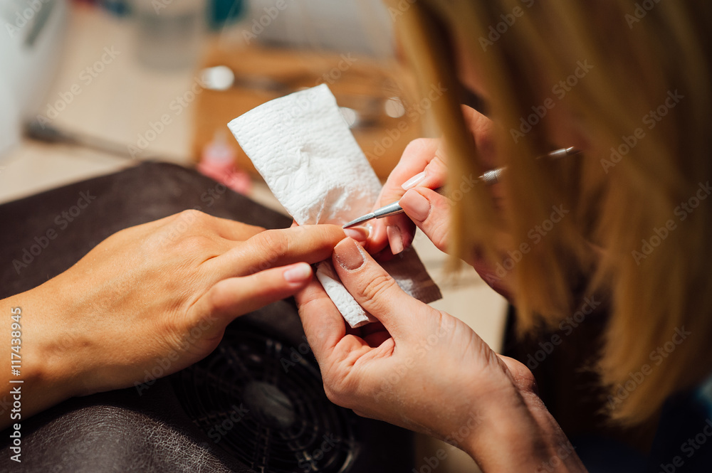 Fototapeta premium Woman in salon receiving manicure