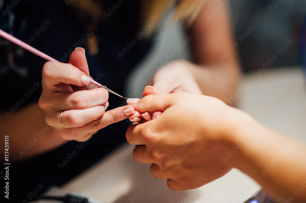 Woman in salon receiving manicure - obrazy, fototapety, plakaty 
