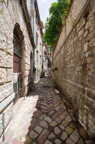 Fototapeta Naklejka Na Ścianę i Meble -  Old stone buildings in historical part of city Kotor in Montenegro with little streets.