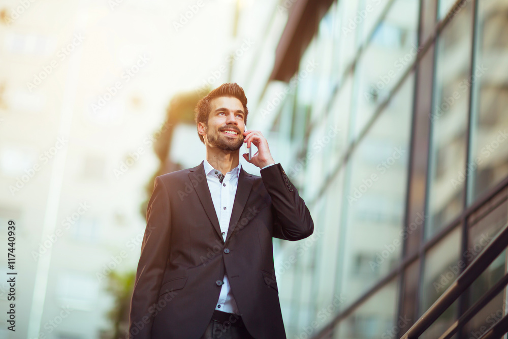 Young businessman talking on his phone outdoors Young businessman talking on his phone outdoors