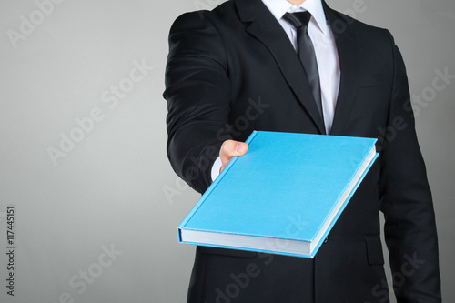 Unrecognizable businessman holding a book closeup photo