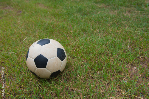 Traditional old soccer ball on green grass.football