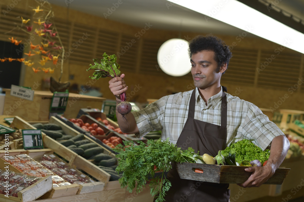 Grocery clerk working in produce aisle of supermarket store Grocery clerk working in produce aisle of supermarket store