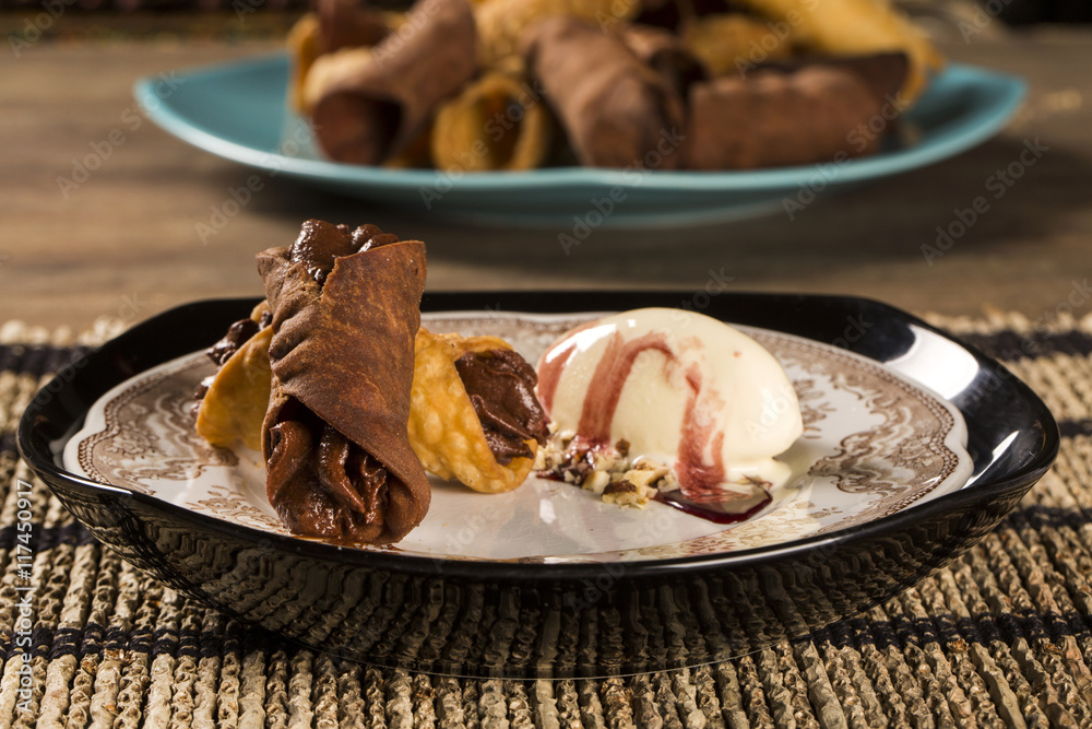 Cannoli with ice cream, chocolate and almonds