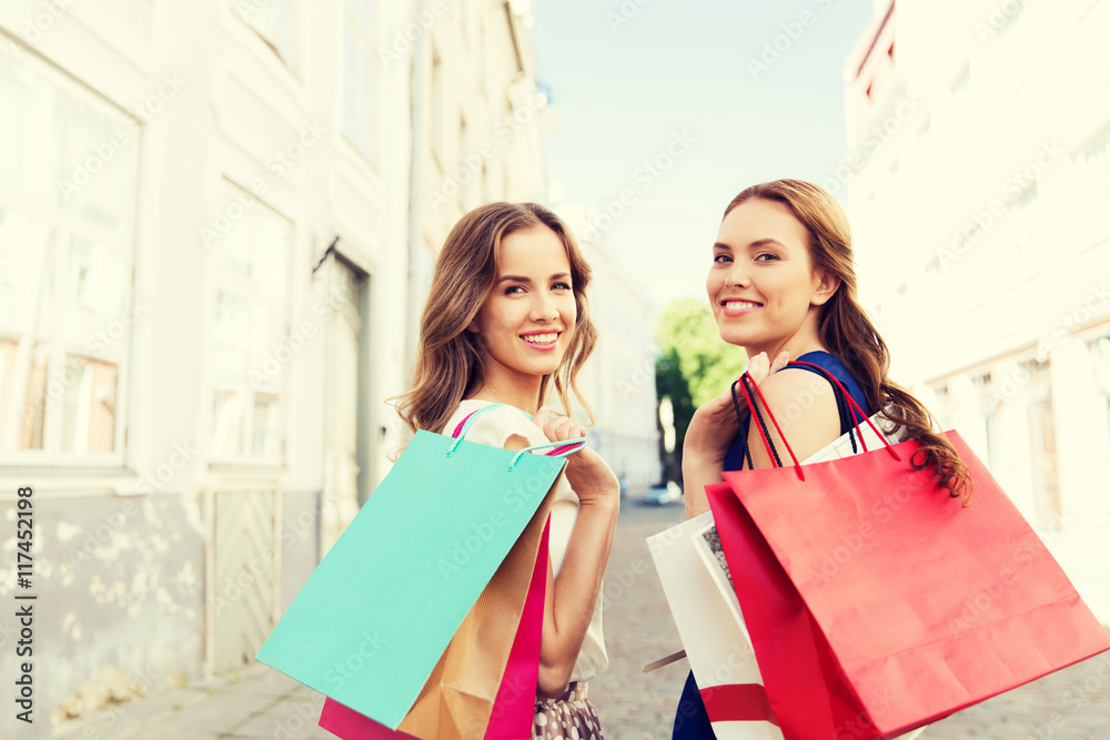 happy women with shopping bags walking in city happy women with shopping bags walking in city
