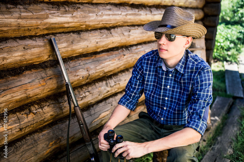 American farmer, wooden house, cowboy hat, sunglasses,