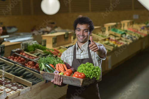 Grocery clerk working in produce aisle of supermarket store