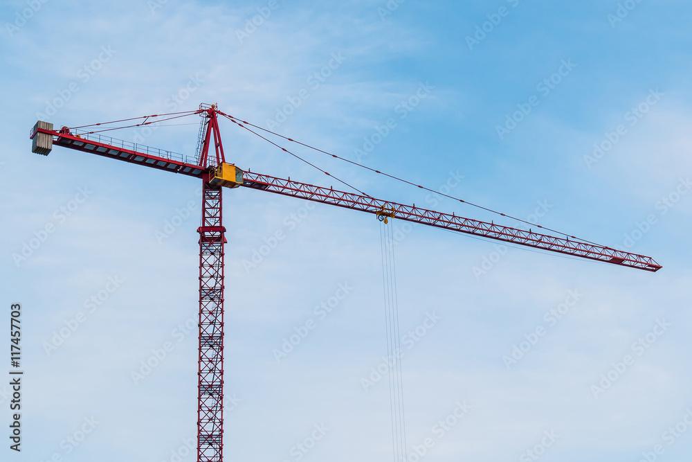 Construction crane on the background of cloudy sky at sunny day. Construction crane on the background of cloudy sky at sunny day.