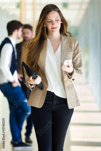 Beautiful young businesswoman using her mobile phone.