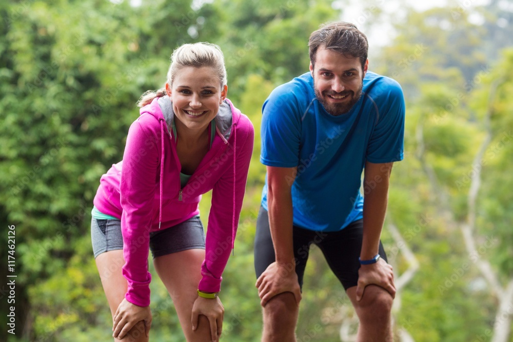 Tired couple taking a break while jogging