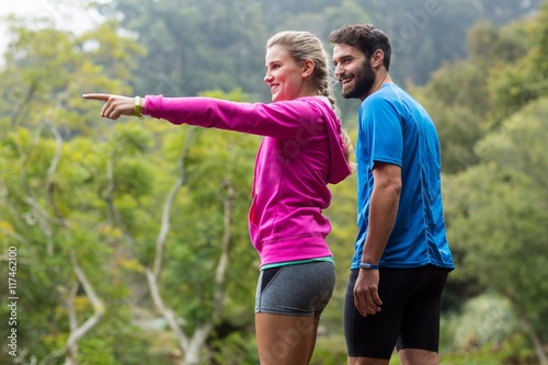 Athletic couple pointing at nature