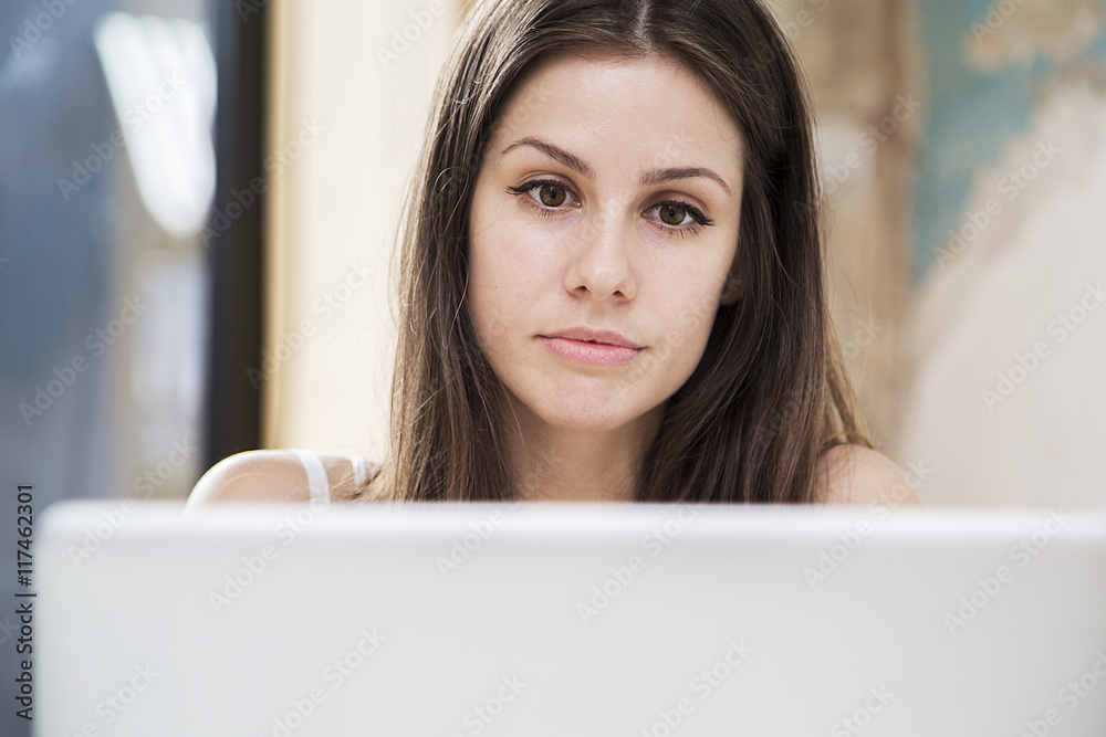 Pretty young woman working on laptop in the office Pretty young woman working on laptop in the office