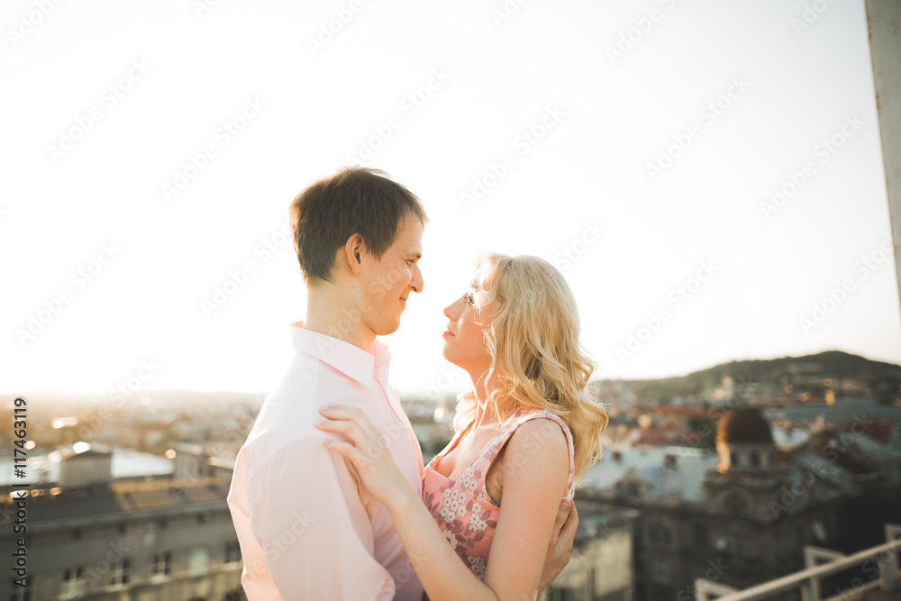 Close up portrait of happy smiling couple in love posing on roof with big balls. Landscape  city